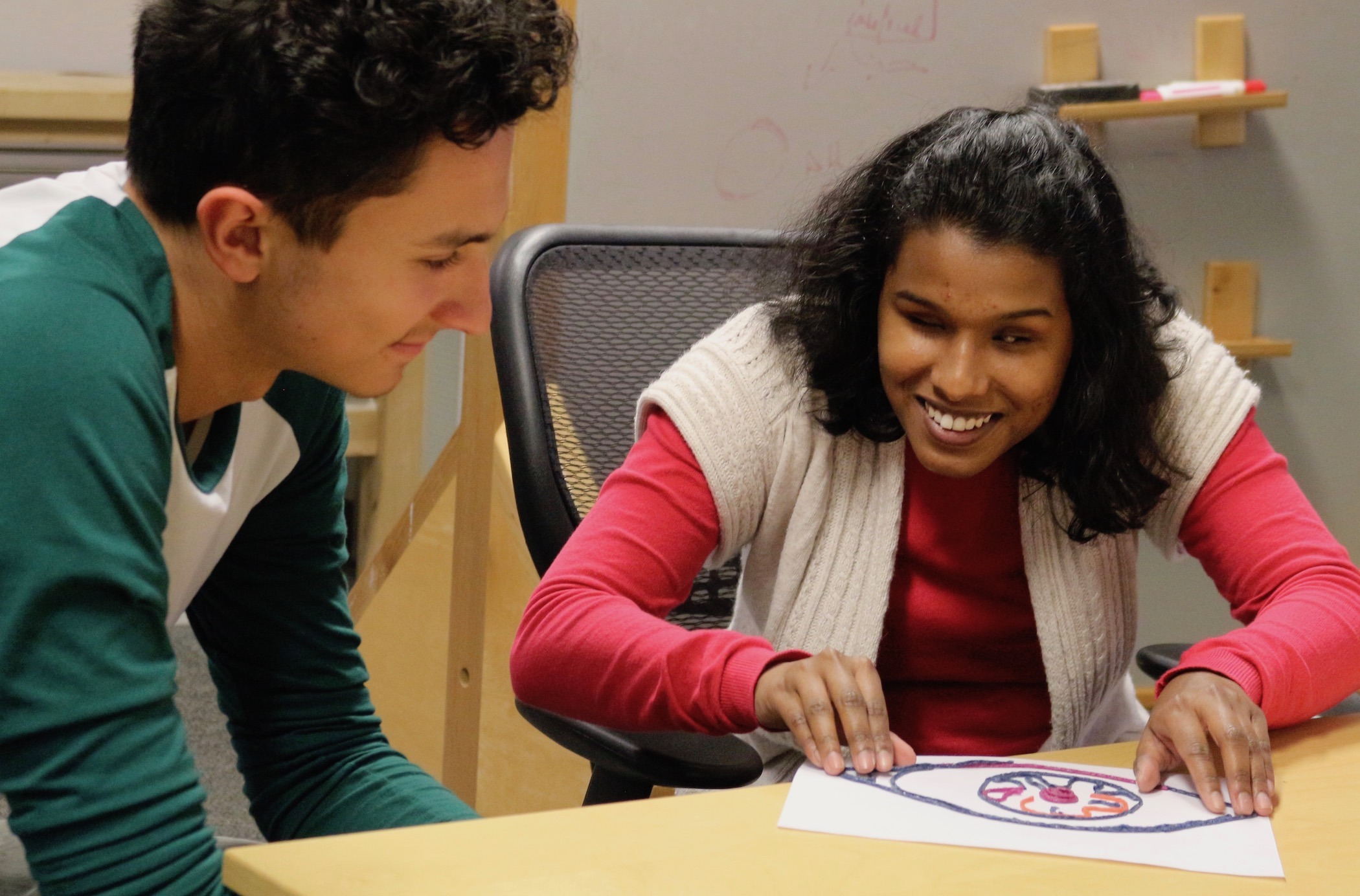 Elijah Gonzales, a sophomore studying civil engineering, discusses his tactile diagram of an eye with Shalini Menon at a design workshop offered through the Build a Better Book project. Photo by Sue Postema Scheeres