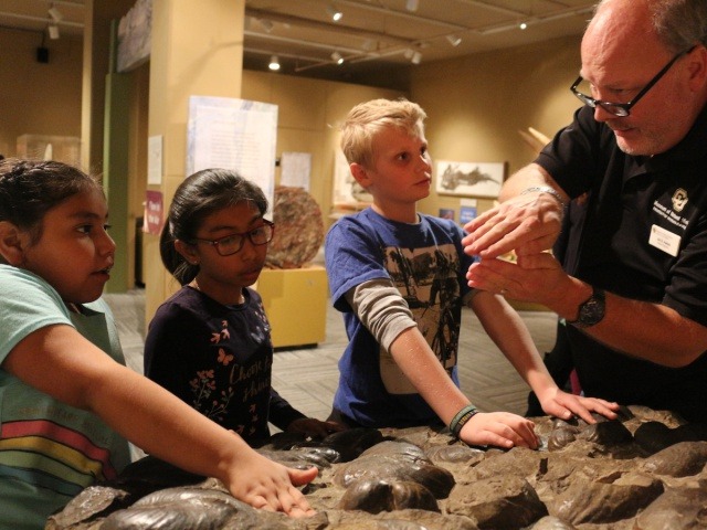 Museum educator Jim Hakala describes a clam shell fossil to University Hill Elementary School students in Boulder. (Photo by Sue Postema Scheeres, CU Boulder)