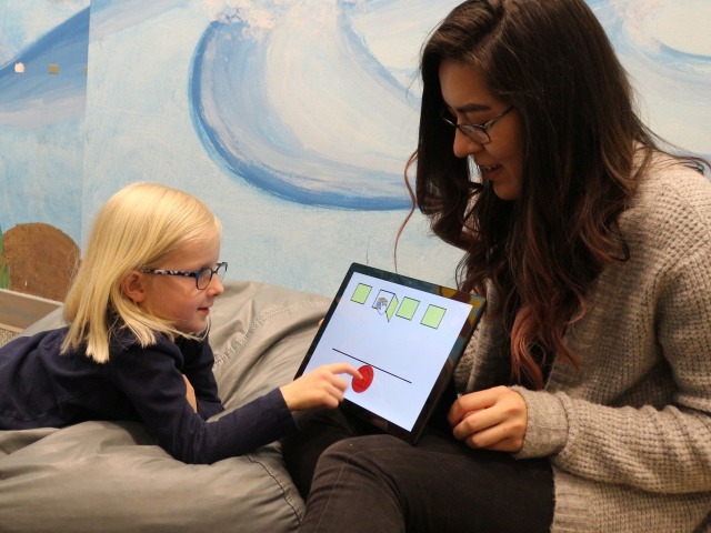 Katie Cluff, 5, plays a game that teaches impulse control with Jade Yonehiro, a CU Boulder psychology and neuroscience graduate student, part of a research program with the Children's Museum of Denver at Marsico Campus.  (Photo by Sue Postema Scheeres)