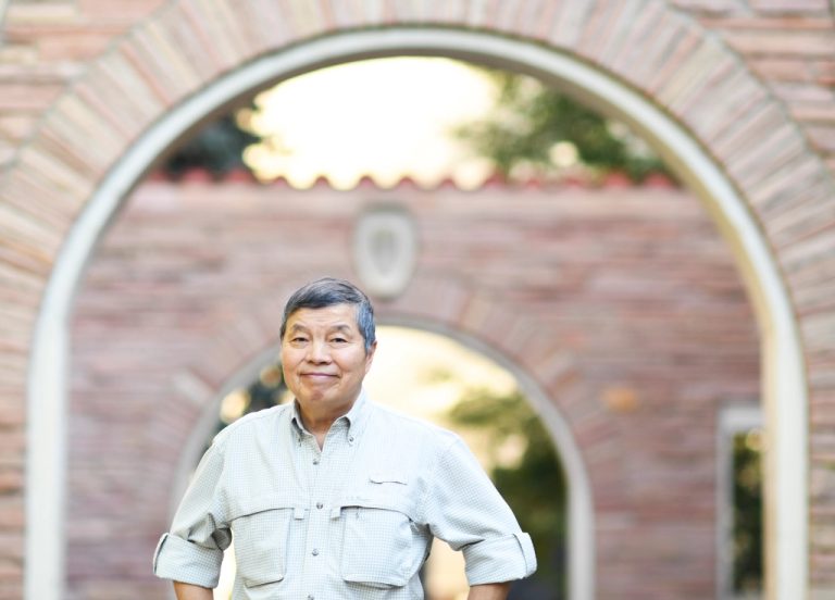 William Wei stands in front of an archway at CU Boulder