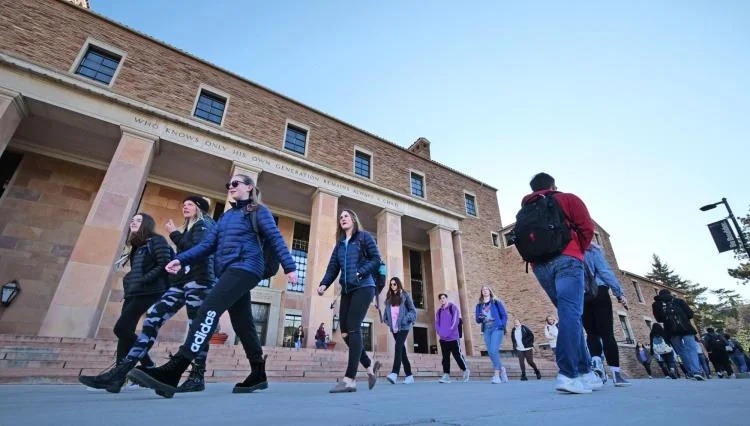 CU Boulder students walk outside of Norlin Library